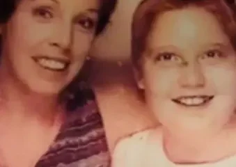 Smiling woman and child posing together indoors