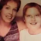 Smiling woman and child posing together indoors