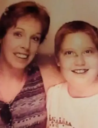 Smiling woman and child posing together indoors