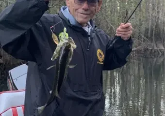 Man holding small fish on boat