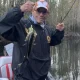Man holding small fish on boat