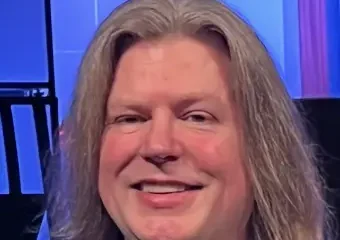 Smiling person with long hair in studio setting
