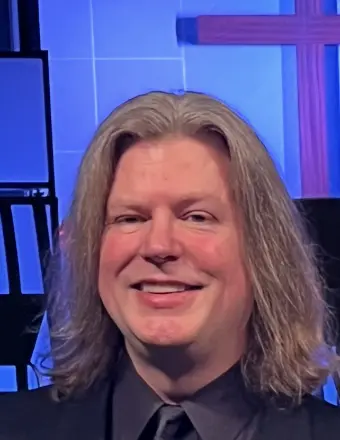 Smiling person with long hair in studio setting