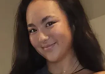 Smiling woman with long dark hair indoors