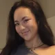 Smiling woman with long dark hair indoors