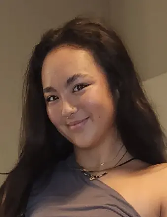 Smiling woman with long dark hair indoors