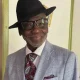 Smiling man in gray suit and black hat