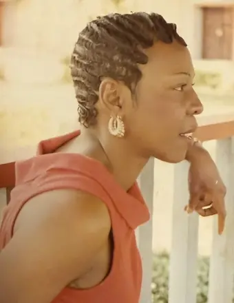 Woman with braided hair leaning on railing
