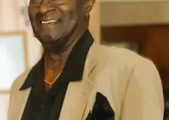 Smiling man in beige blazer and cap