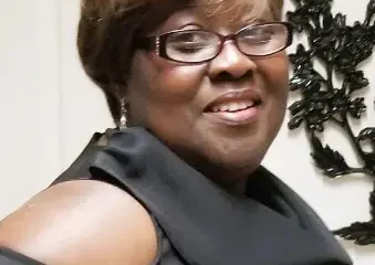 Smiling woman in black top and glasses