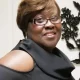 Smiling woman in black top and glasses