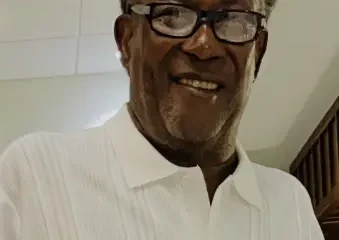 Smiling older man with glasses in white shirt