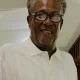 Smiling older man with glasses in white shirt