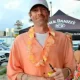 Man in orange shirt with lei holding drink