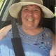 Smiling woman wearing sunhat in car seat