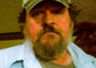 Bearded man wearing camouflage cap indoors