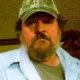 Bearded man wearing camouflage cap indoors