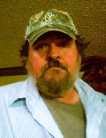 Bearded man wearing camouflage cap indoors