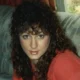 Woman with curly dark hair in red top