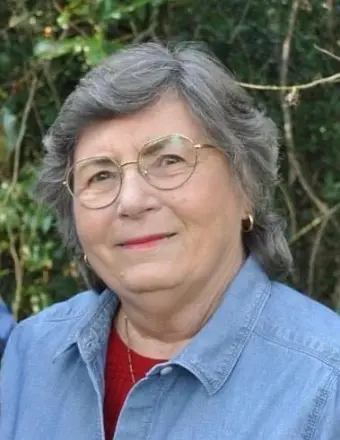 Older woman with glasses smiling outdoors