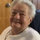 Smiling elderly woman with short white hair indoors