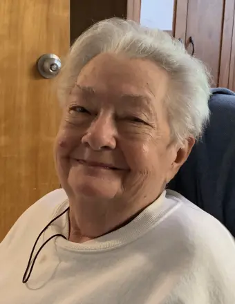 Smiling elderly woman with short white hair indoors