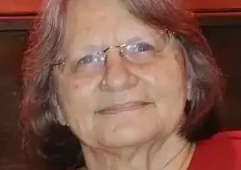 Elderly woman with glasses wearing red top