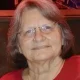Elderly woman with glasses wearing red top