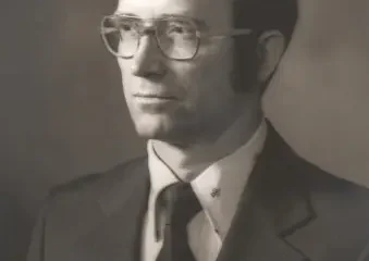 Black-and-white portrait of man in suit and glasses