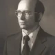 Black-and-white portrait of man in suit and glasses