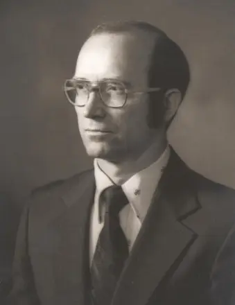 Black-and-white portrait of man in suit and glasses