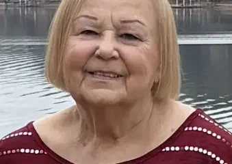 Elderly woman smiling by lakeside