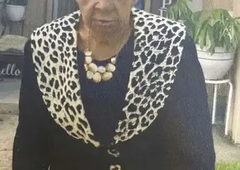 Elderly woman wearing black outfit with leopard print trim