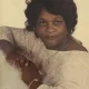 Woman leaning on surface wearing light blouse