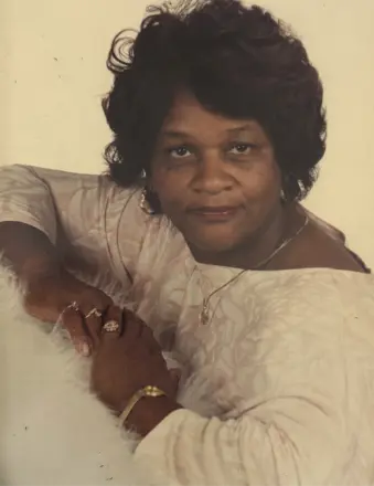 Woman leaning on surface wearing light blouse