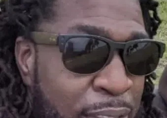 Man with dreadlocks wearing sunglasses outdoors