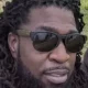 Man with dreadlocks wearing sunglasses outdoors