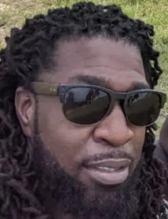 Man with dreadlocks wearing sunglasses outdoors