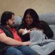 Couple holding newborn baby on couch