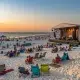 Beachfront concert at sunset with seated audience