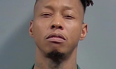 Man in green jail uniform mugshot