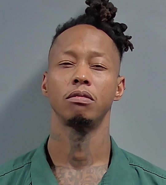 Man in green jail uniform mugshot
