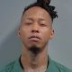 Man in green jail uniform mugshot