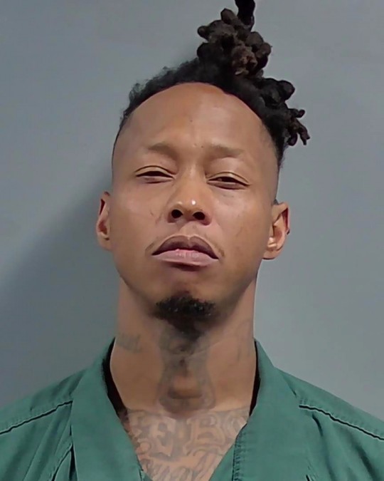 Man in green jail uniform mugshot