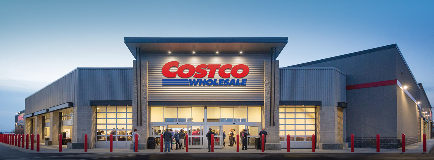 Costco Wholesale storefront at dusk with shoppers