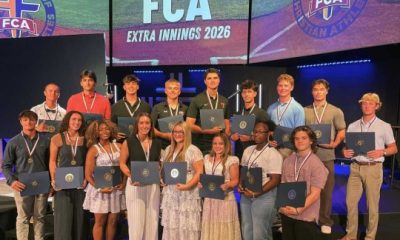 Students holding certificates on FCA stage event