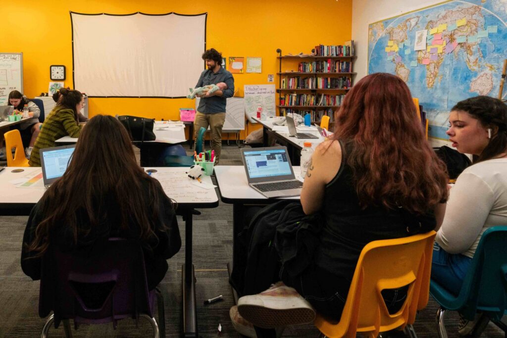 Teacher holding baby doll in classroom discussion