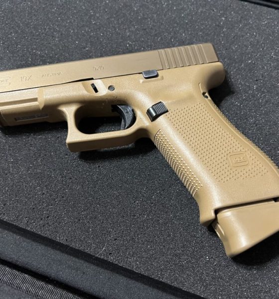 Tan Glock 19X pistol on black surface