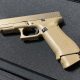Tan Glock 19X pistol on black surface