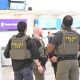 ICE police officers standing in airport terminal